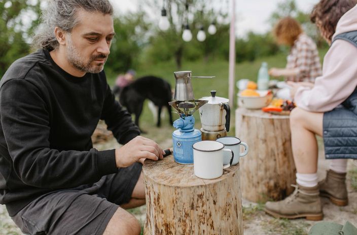 Man Using a Camping Stove for Coffee
